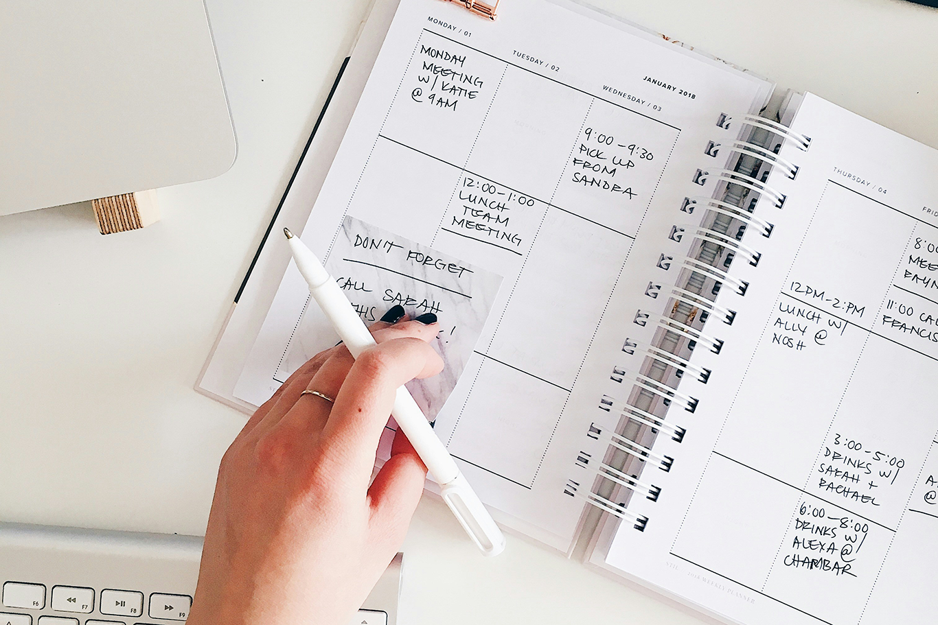 hand with pencil writing on calendar